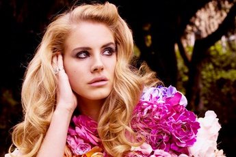 Lana Del Rey in a forest looking off in the distance.